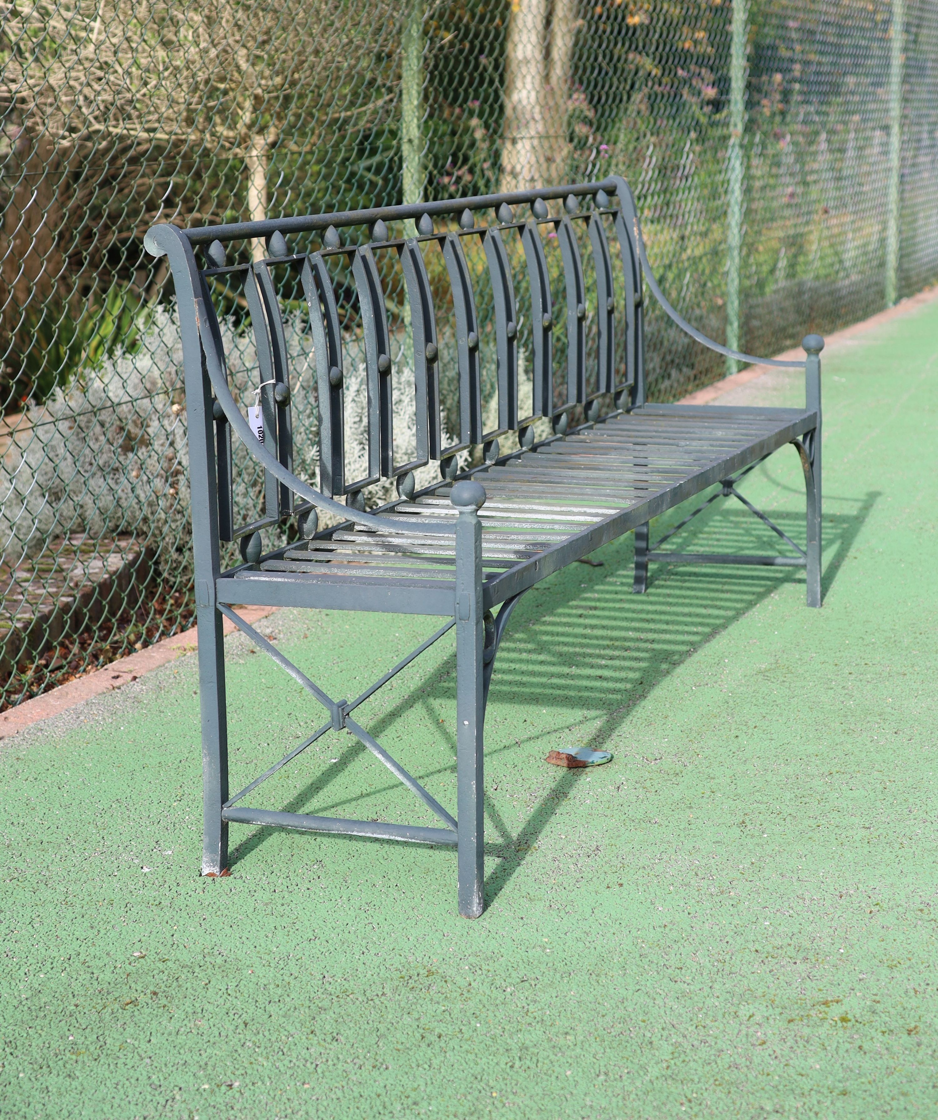 A green painted wrought iron garden bench, W.204cm D.49cm H.87cm